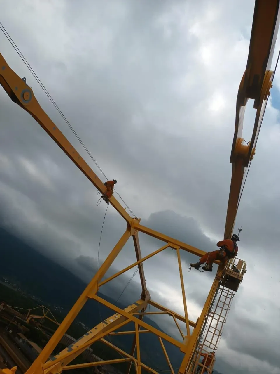 Operador em rapel na lança amarela de um carregador de navios